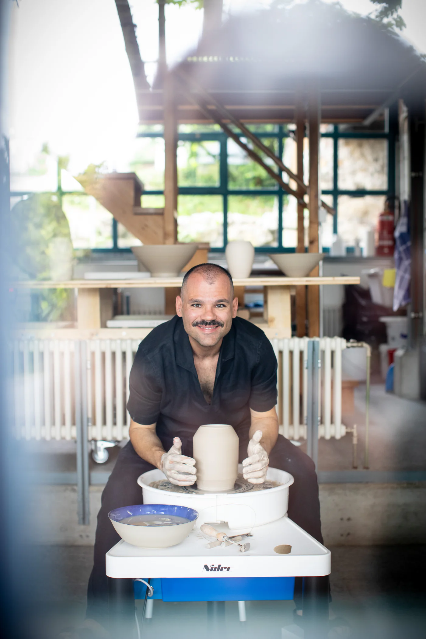 Fabiano Calcò lächelnd an der Töpferscheibe in seinem Atelier in Kirchdorf bei Baden
