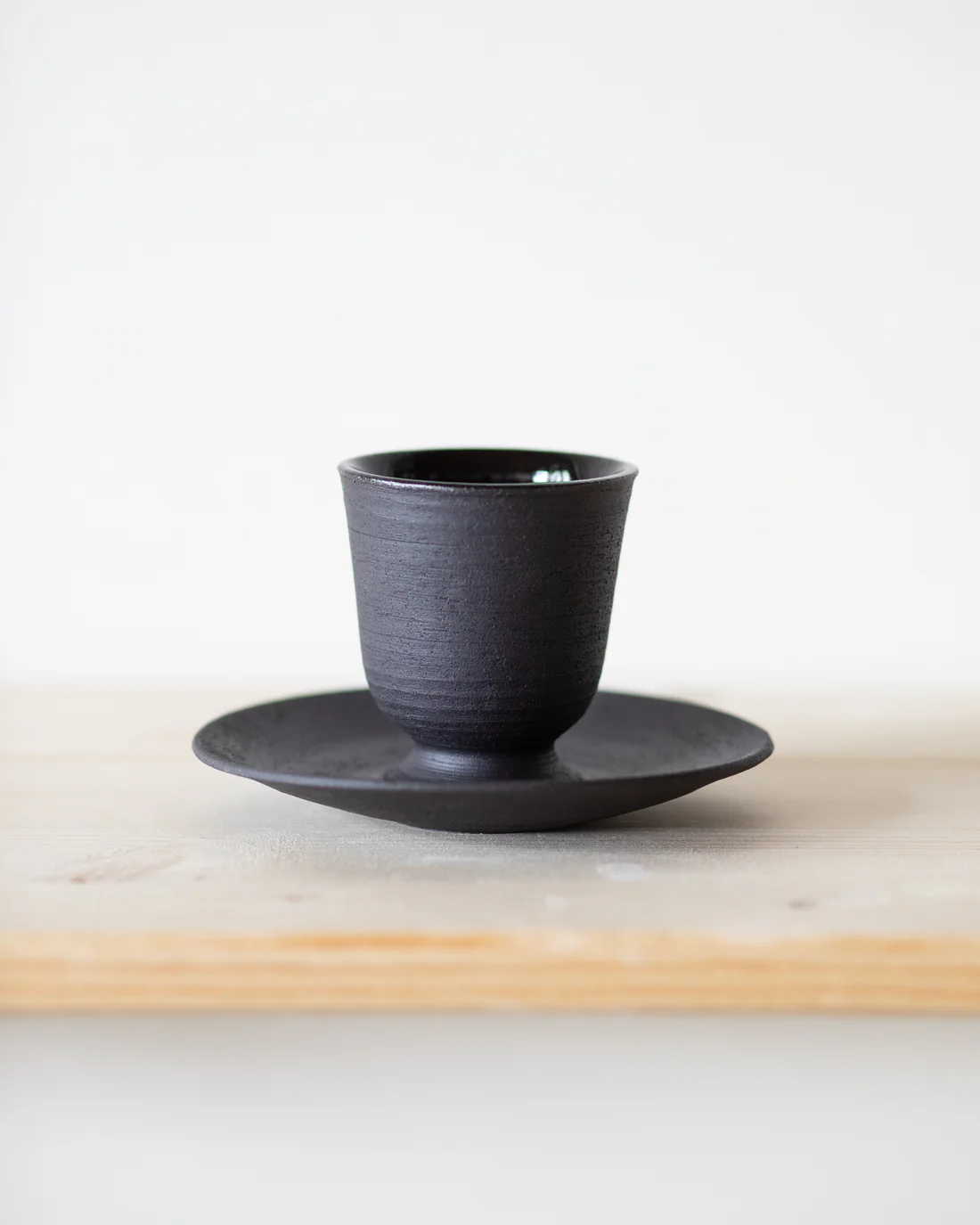 Espressotasse mit Untertasse aus schwarzem Steinzeug — handgemachte Keramik