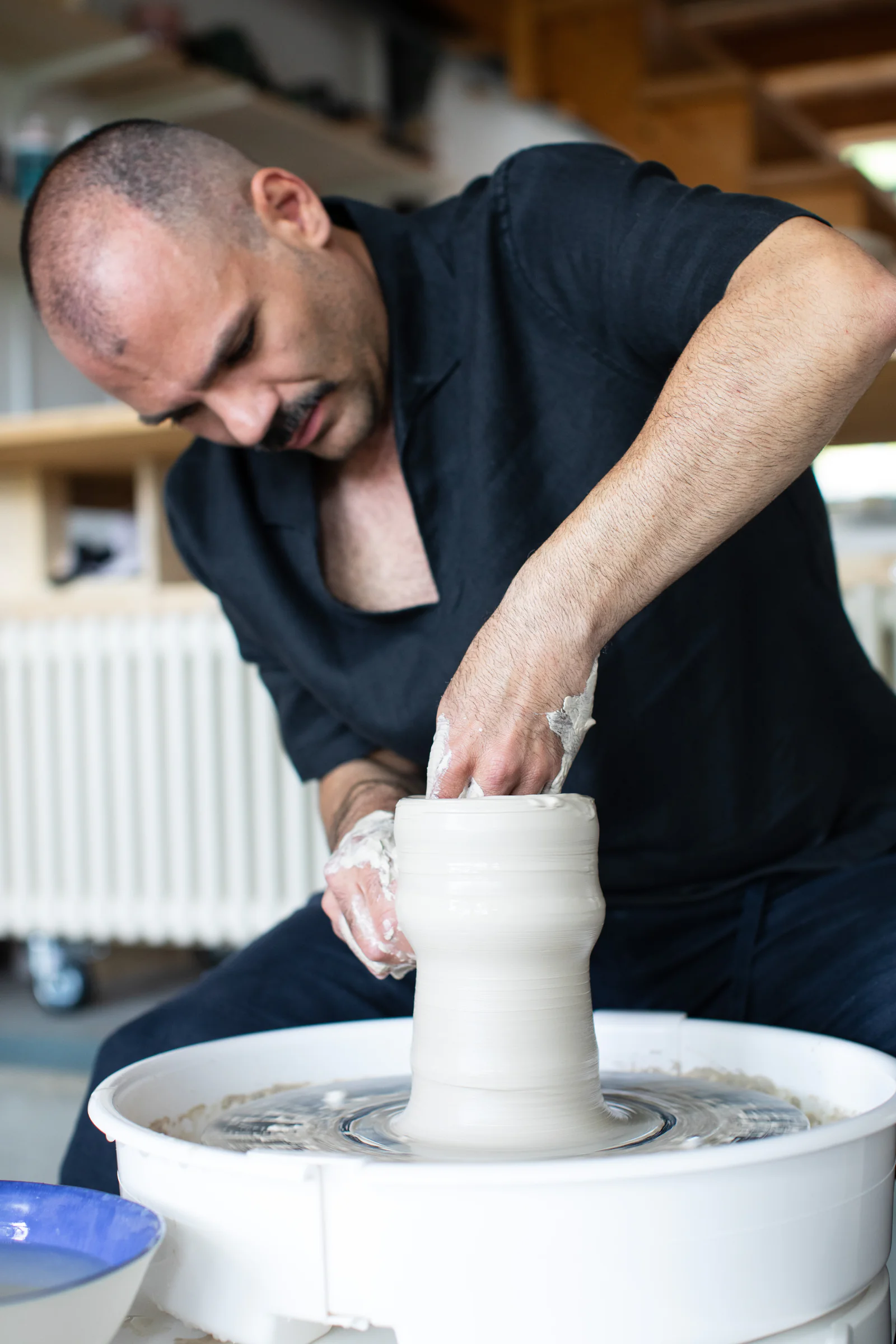 Fabiano Calcò dreht ein hohes Gefäss an der Töpferscheibe in seinem Atelier in Kirchdorf bei Baden